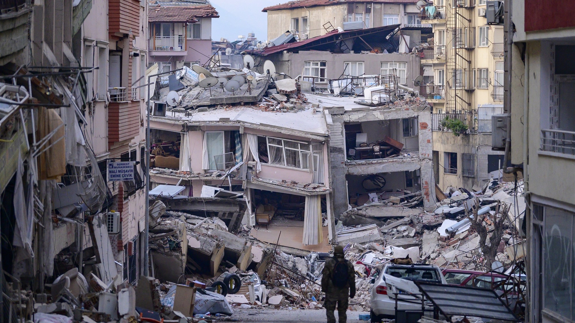 Een Turkse soldaat loopt langs door de aardbevingen verwoeste gebouwen in Hatay, 12 februari 2023