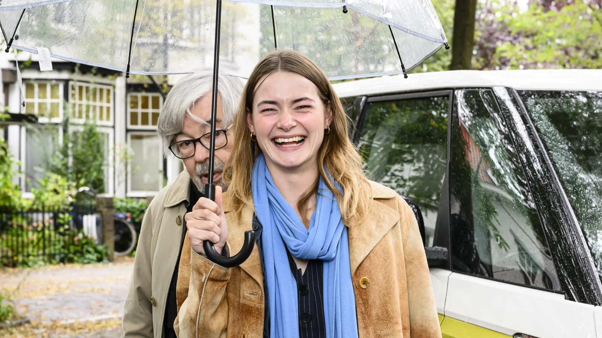 Emma Wortelboer en Maarten van Rossem onder een paraplu